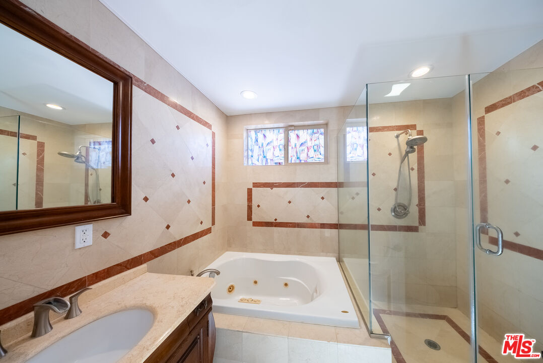 13847 Gilmore Street Van Nuys, CA 91401 - Photo 17 of 43 a bathroom with a sink a large mirror and shower