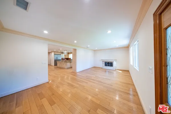 a view of empty room with a window and a kitchen
