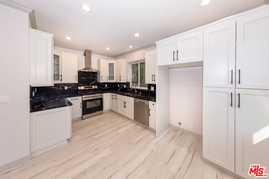 13847 Gilmore Street Van Nuys, CA 91401 - Photo 35 of 43 a kitchen with granite countertop white cabinets and white appliances