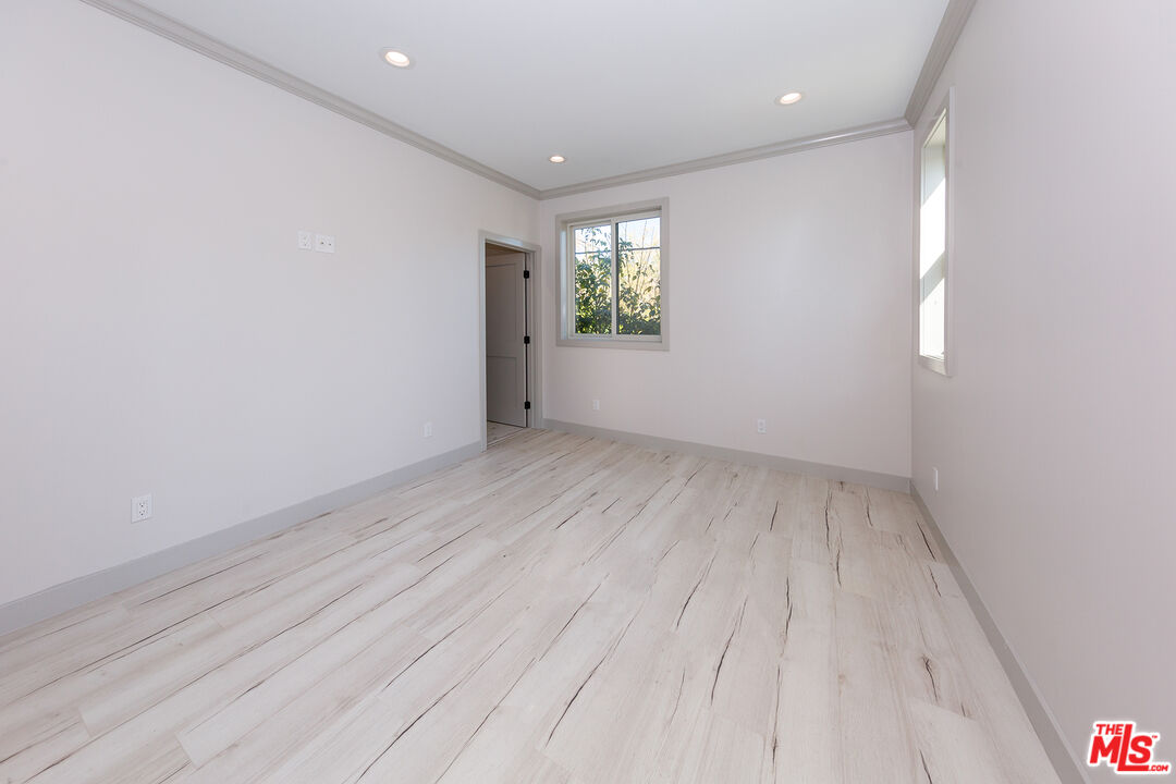 13847 Gilmore Street Van Nuys, CA 91401 - Photo 40 of 43 a view of an empty room with wooden floor and a window