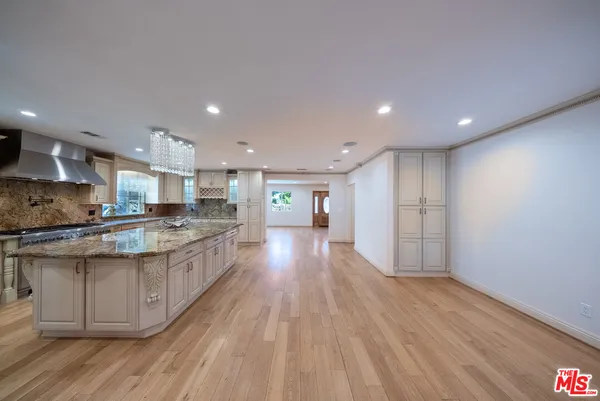 a large kitchen with stainless steel appliances granite countertop a large counter top a sink and a stove