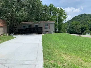a front view of a house with a yard and trees