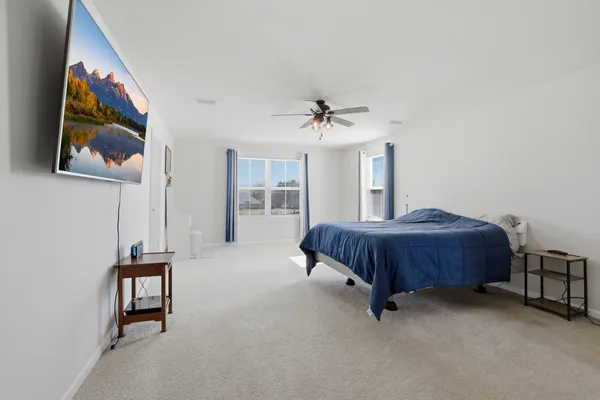 a spacious bedroom with a bed and a chandelier