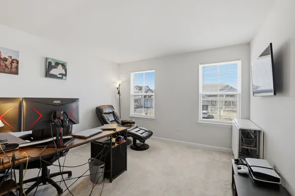 a view of a workspace with furniture and a window