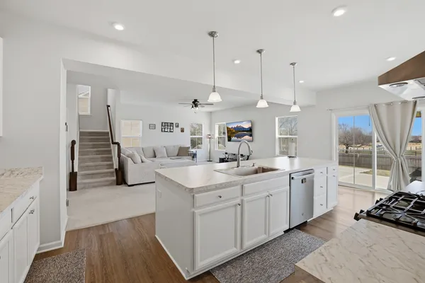 a kitchen with a sink stove and wooden floor