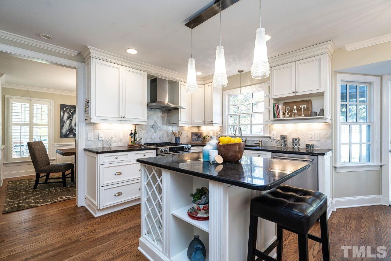 3434 Churchill Road Raleigh, NC 27607 - Photo 10 of 30 a kitchen with granite countertop a stove a sink and chairs