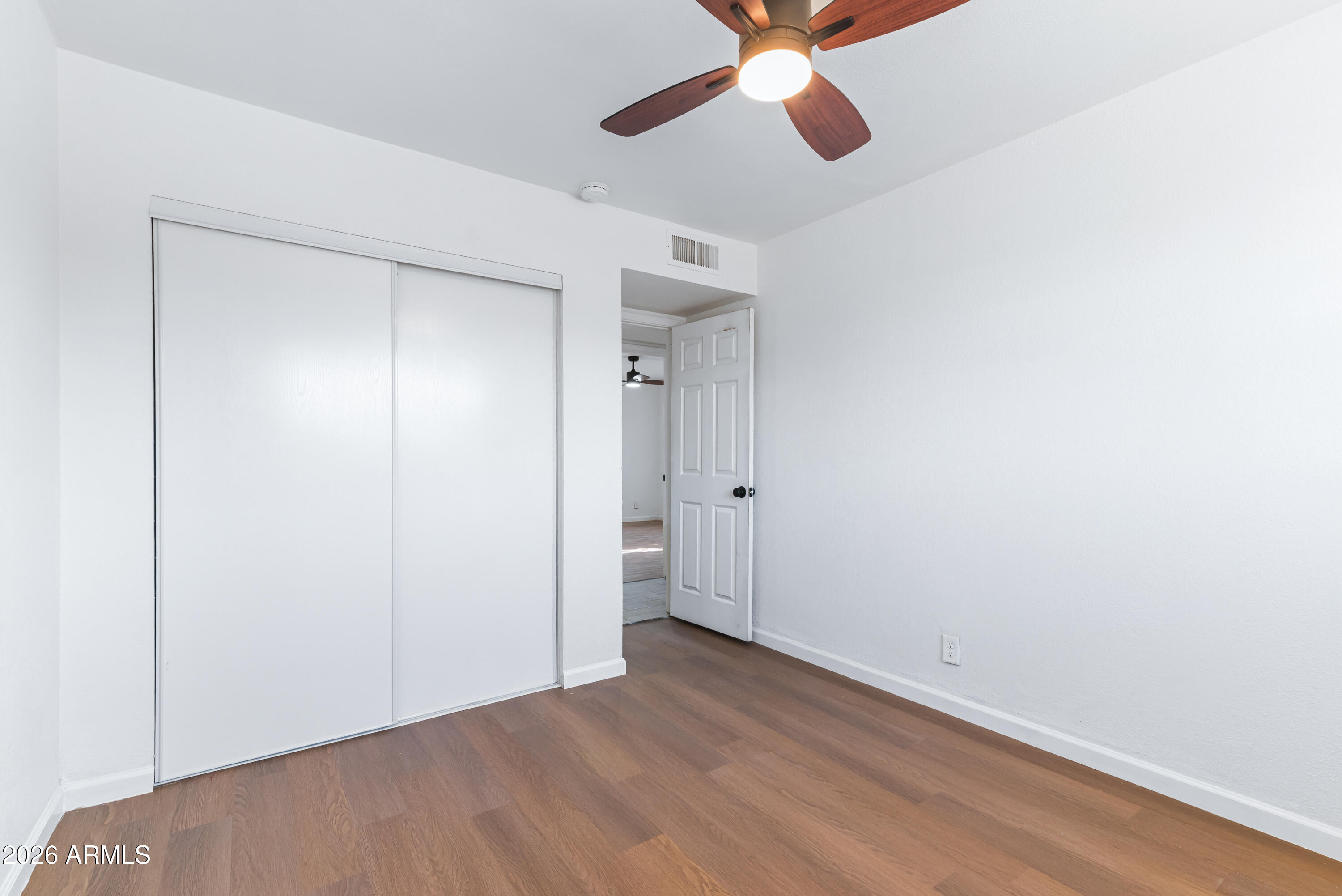 860 West McLellan Road Mesa, AZ 85201 - Photo 19 of 26 an empty room with wooden floor closet and windows