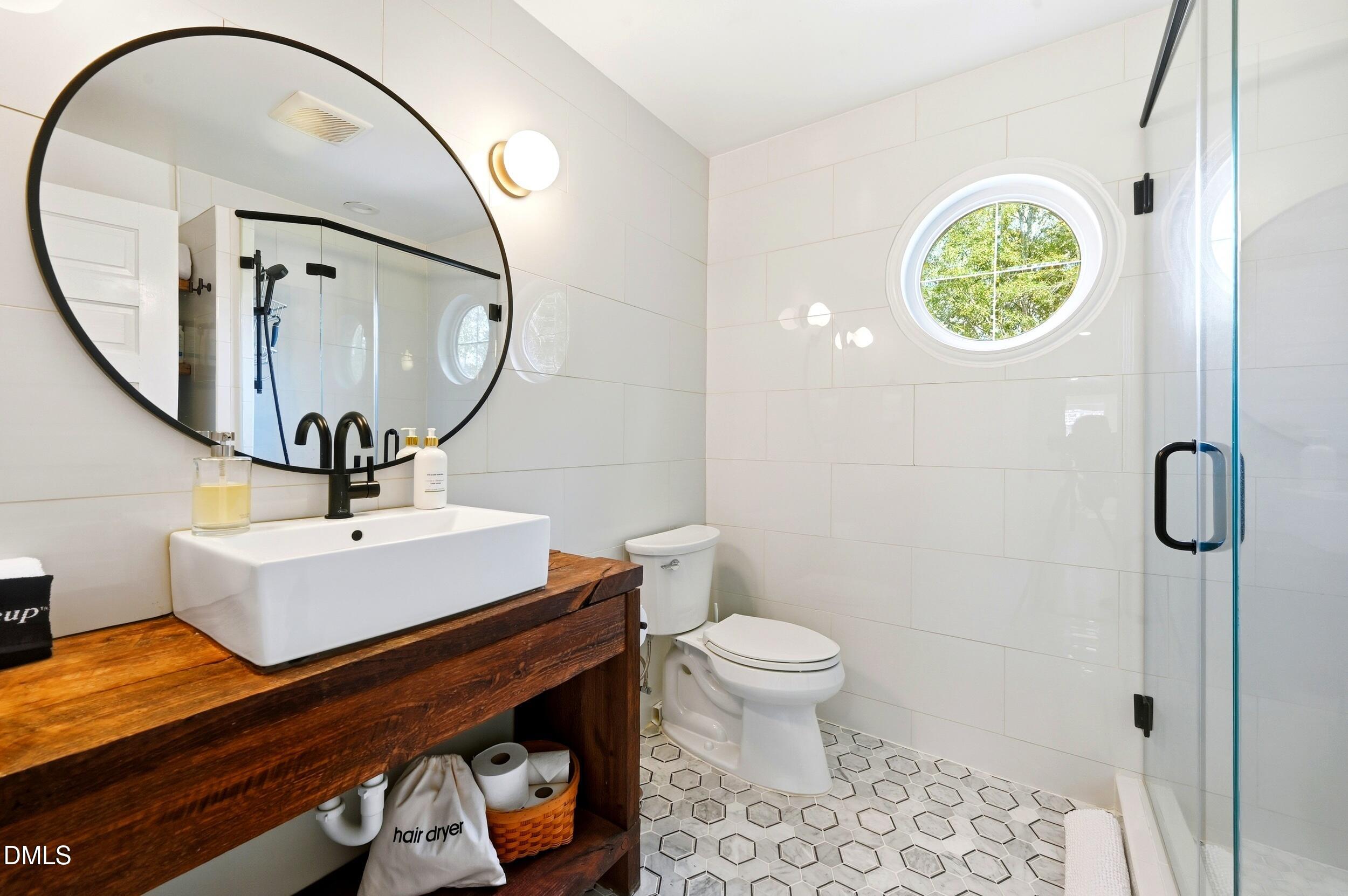 1451 Hawkins Road Hurdle Mills, NC 27541 - Photo 11 of 69 a bathroom with a sink a mirror and a toilet