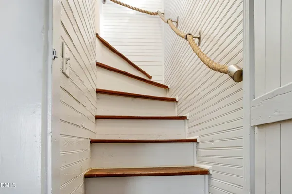 a backyard of a house with plants and large trees