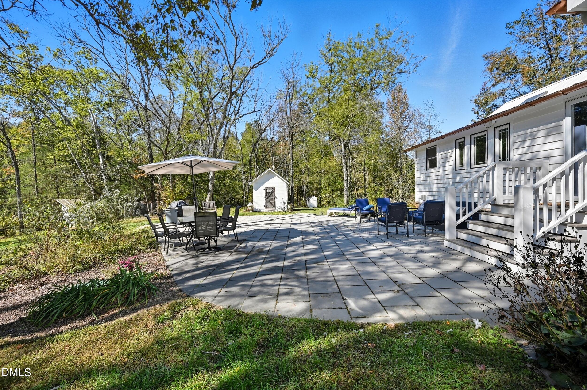 1451 Hawkins Road Hurdle Mills, NC 27541 - Photo 23 of 69 a view of a patio with table and chairs under an umbrella
