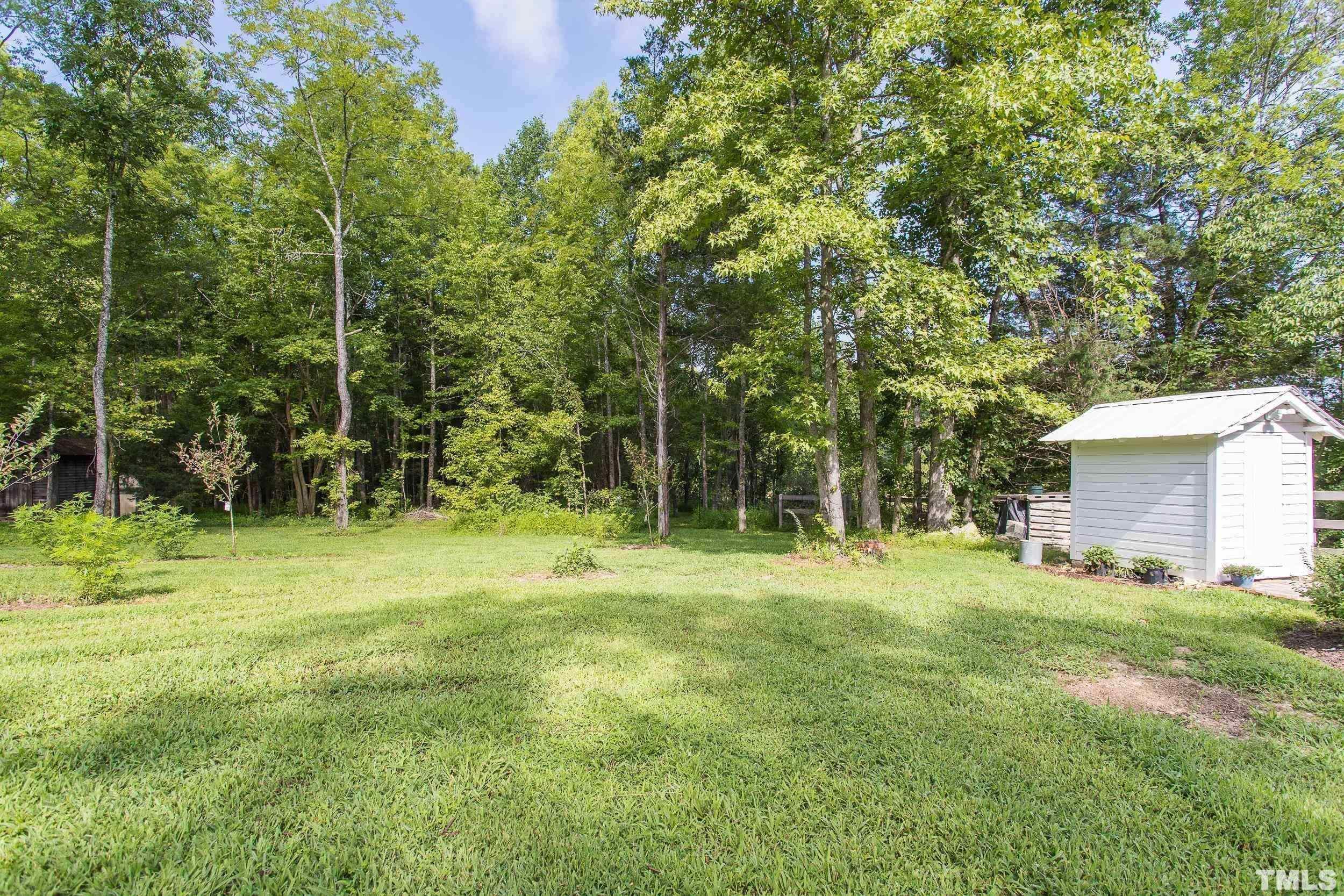 1451 Hawkins Road Hurdle Mills, NC 27541 - Photo 51 of 69 a backyard of a house with plants and large trees