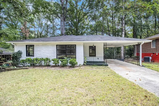 front view of house with a yard and potted plants