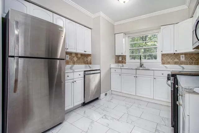 a kitchen with appliances cabinets a sink and a window