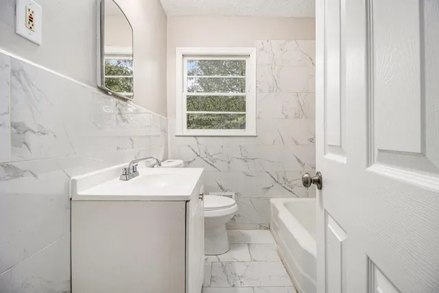 a bathroom with a sink toilet and mirror