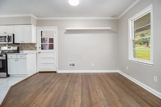 a view of kitchen with wooden floor electronic appliances and window