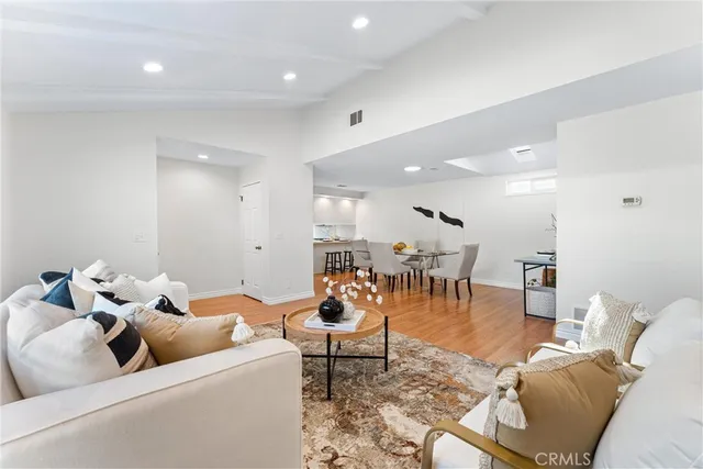 a kitchen with a sink a stove a refrigerator and white cabinets with wooden floor