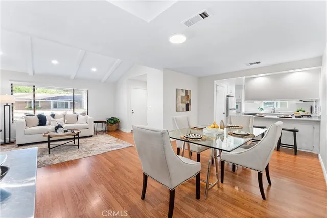 a kitchen with a refrigerator a sink and wooden floor