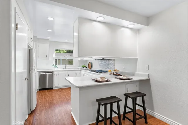 a kitchen with white cabinets and appliances