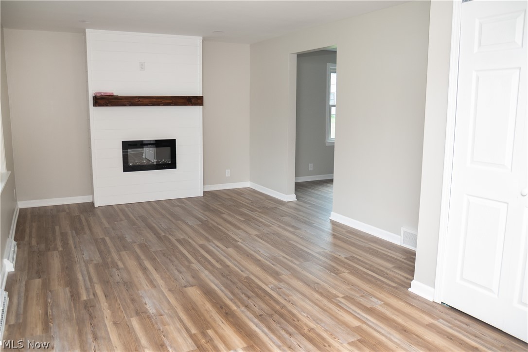 6666 Clingan Road Youngstown, OH 44514 - Photo 13 of 41 Living room with new LVT flooring, paint, new electric fireplace with remote