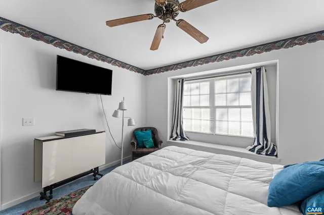 a bedroom with a bed a window and a television