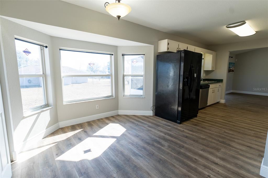 15651 Southwest 19th Terrace Ocala, FL 34473 - Photo 21 of 68 a view of a kitchen with wooden floor refrigerator and windows