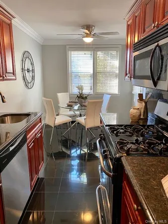 a kitchen with stainless steel appliances granite countertop a stove top oven a sink a dining table and chairs