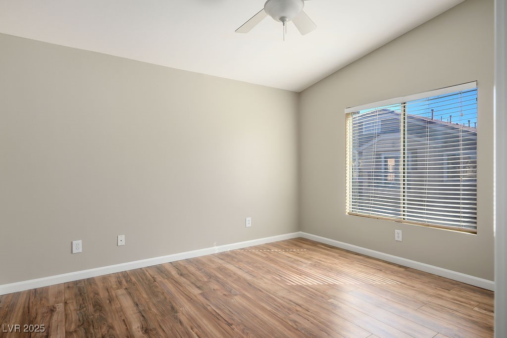 6610 Tumbleweed Ridge Lane, Unit 101 Henderson, NV 89011 - Photo 18 of 24 Empty room with vaulted ceiling, wood finished floors, and a ceiling fan