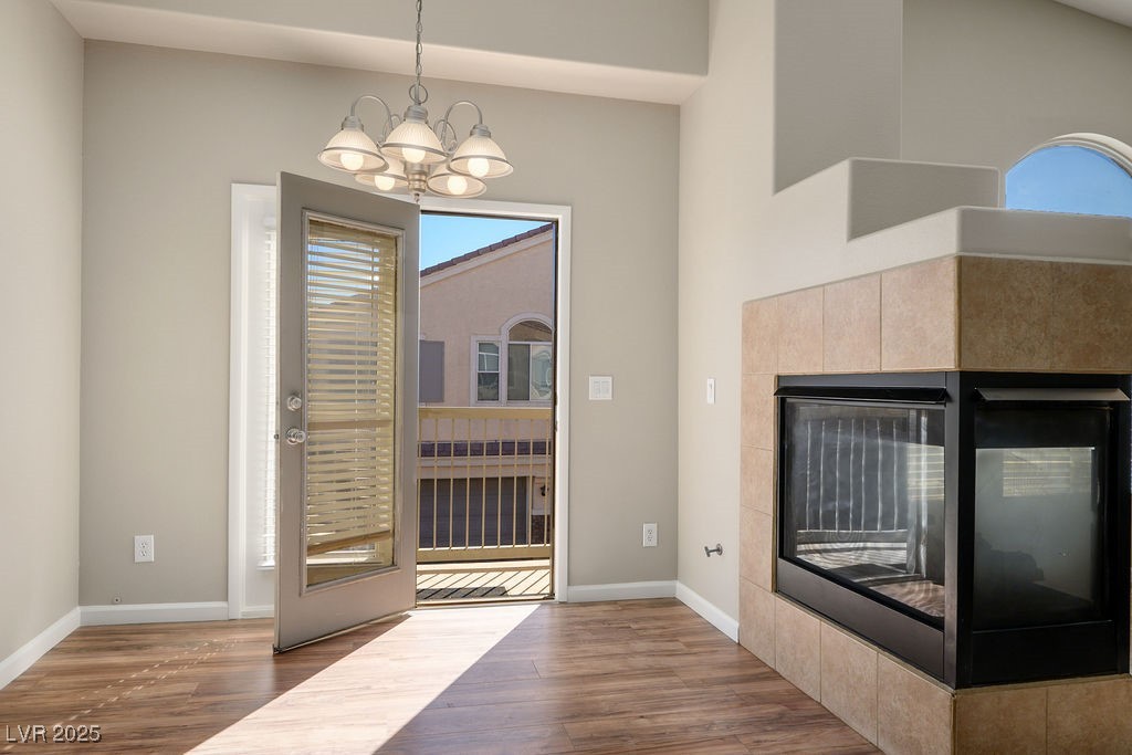 6610 Tumbleweed Ridge Lane, Unit 101 Henderson, NV 89011 - Photo 6 of 24 Foyer entrance with a chandelier, wood finished floors, and a tile fireplace