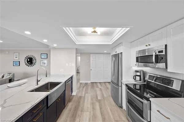 a large kitchen with a large counter top space stainless steel appliances and cabinets