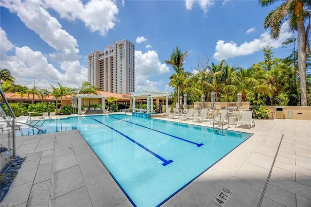 a view of a swimming pool with a lawn chairs and a fire pit