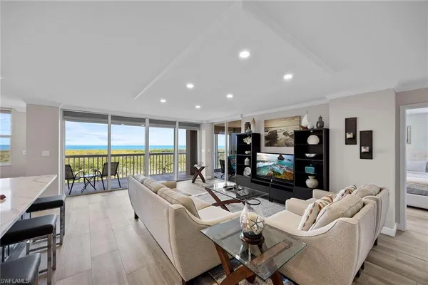 a living room with furniture floor to ceiling window and walk in closet