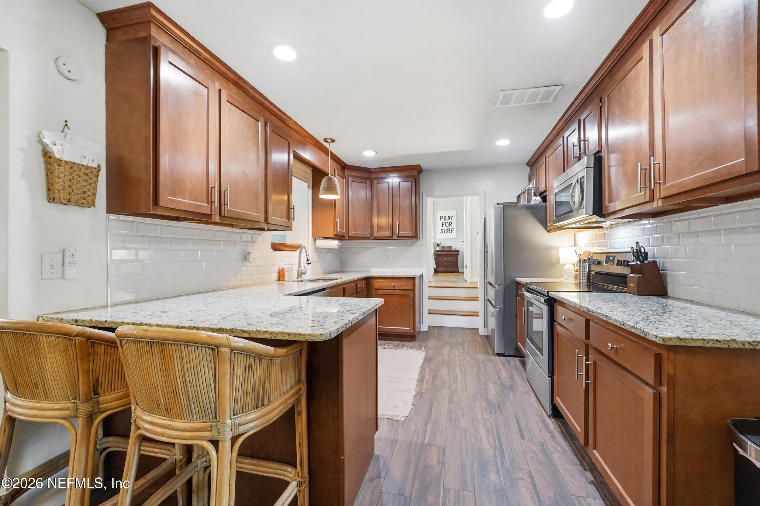 10524 Beverly Nalle Road Jacksonville, FL 32225 - Photo 11 of 28 a kitchen with stainless steel appliances granite countertop wooden cabinets refrigerator and microwave
