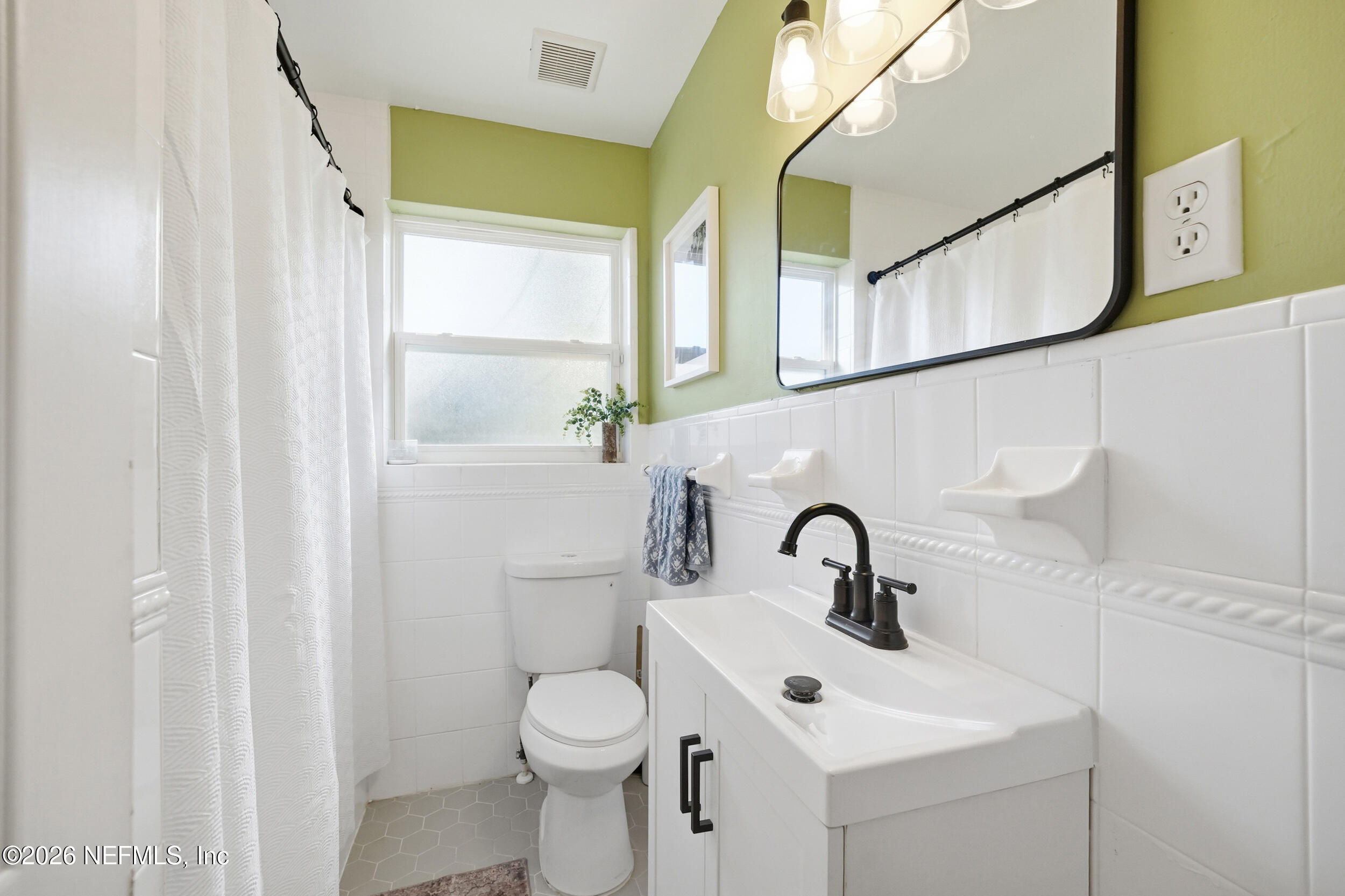 10524 Beverly Nalle Road Jacksonville, FL 32225 - Photo 16 of 28 a bathroom with a sink a toilet and mirror