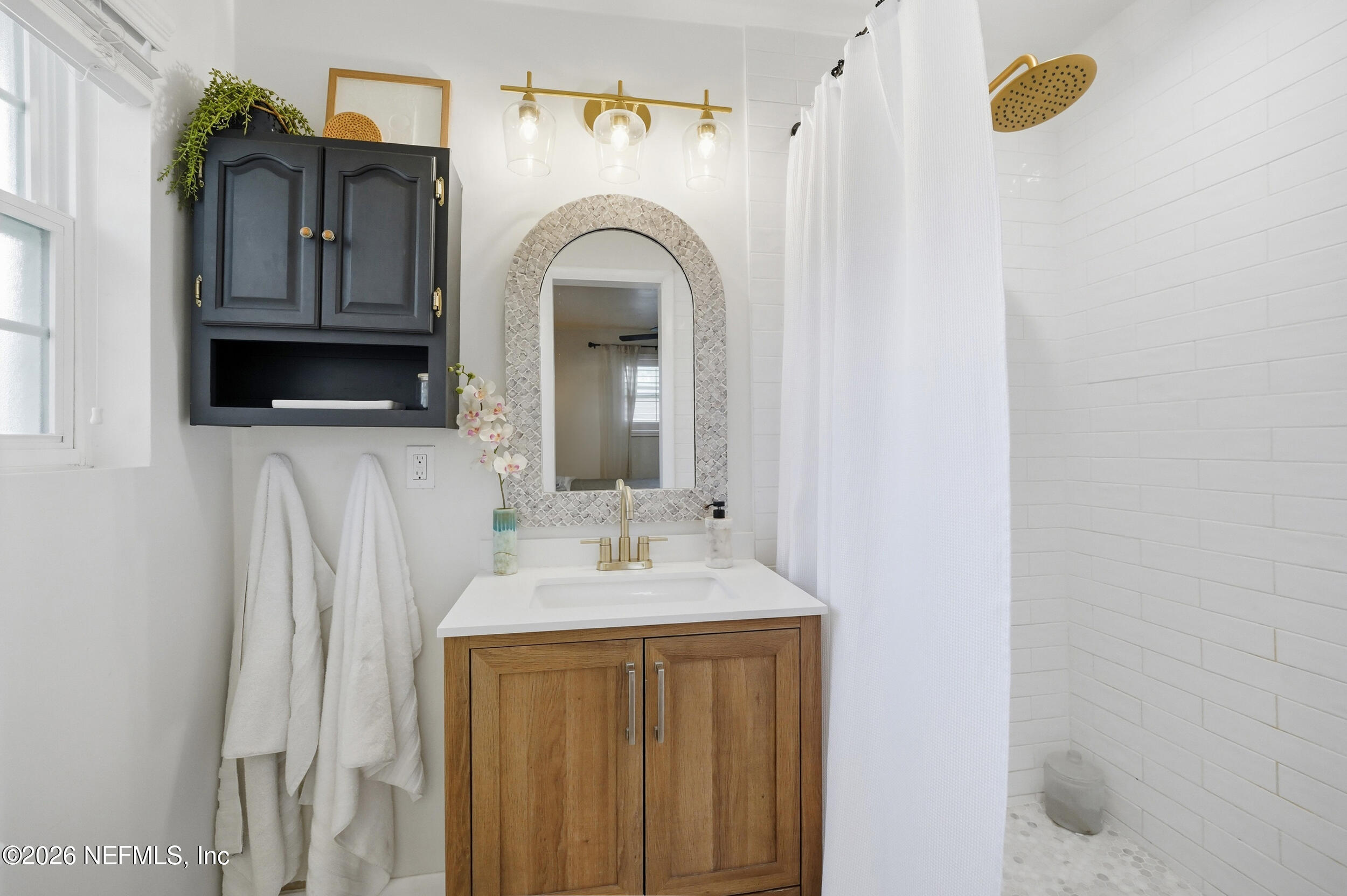 10524 Beverly Nalle Road Jacksonville, FL 32225 - Photo 21 of 28 a bathroom with a sink a mirror and bathtub