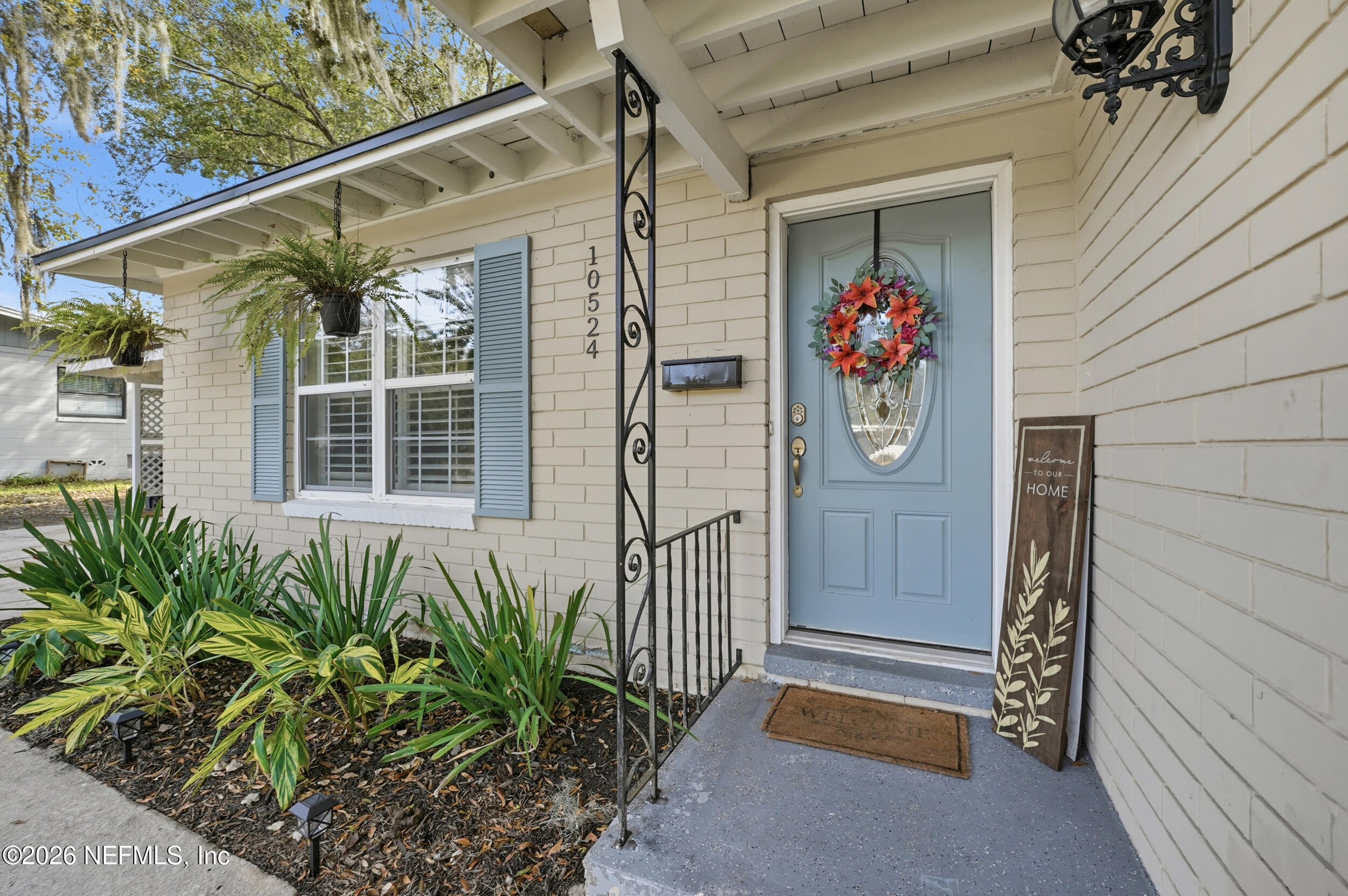 10524 Beverly Nalle Road Jacksonville, FL 32225 - Photo 3 of 28 a house with potted plants in front of door