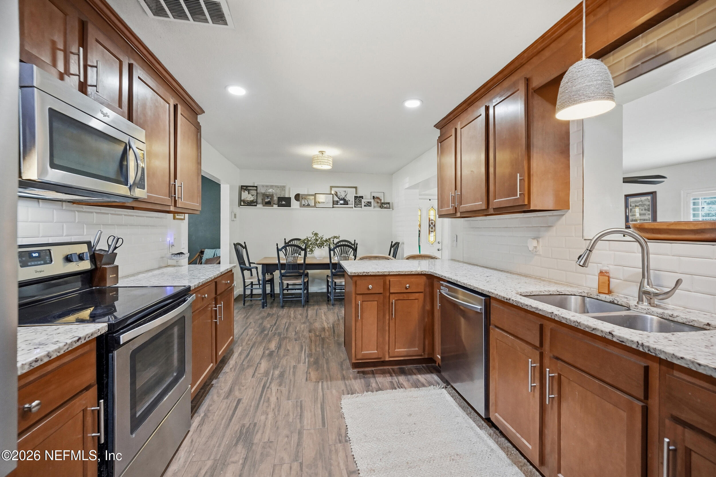 10524 Beverly Nalle Road Jacksonville, FL 32225 - Photo 8 of 28 a kitchen with stainless steel appliances granite countertop sink stove top oven and cabinets