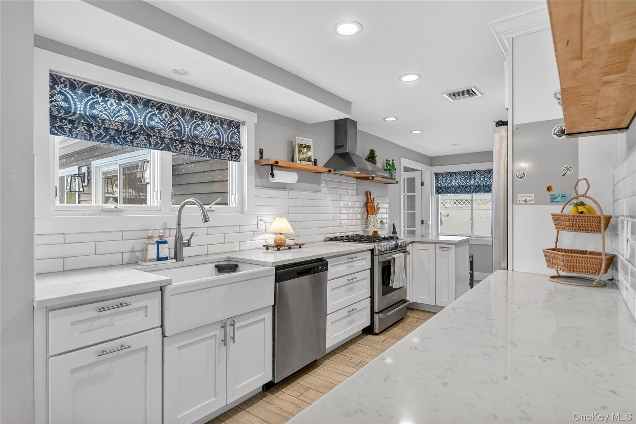 18 Lambert Lane New Rochelle, NY 10804 - Photo 11 of 47 Kitchen featuring white cabinetry, light stone countertops, open shelves, appliances with stainless steel finishes, and recessed lighting