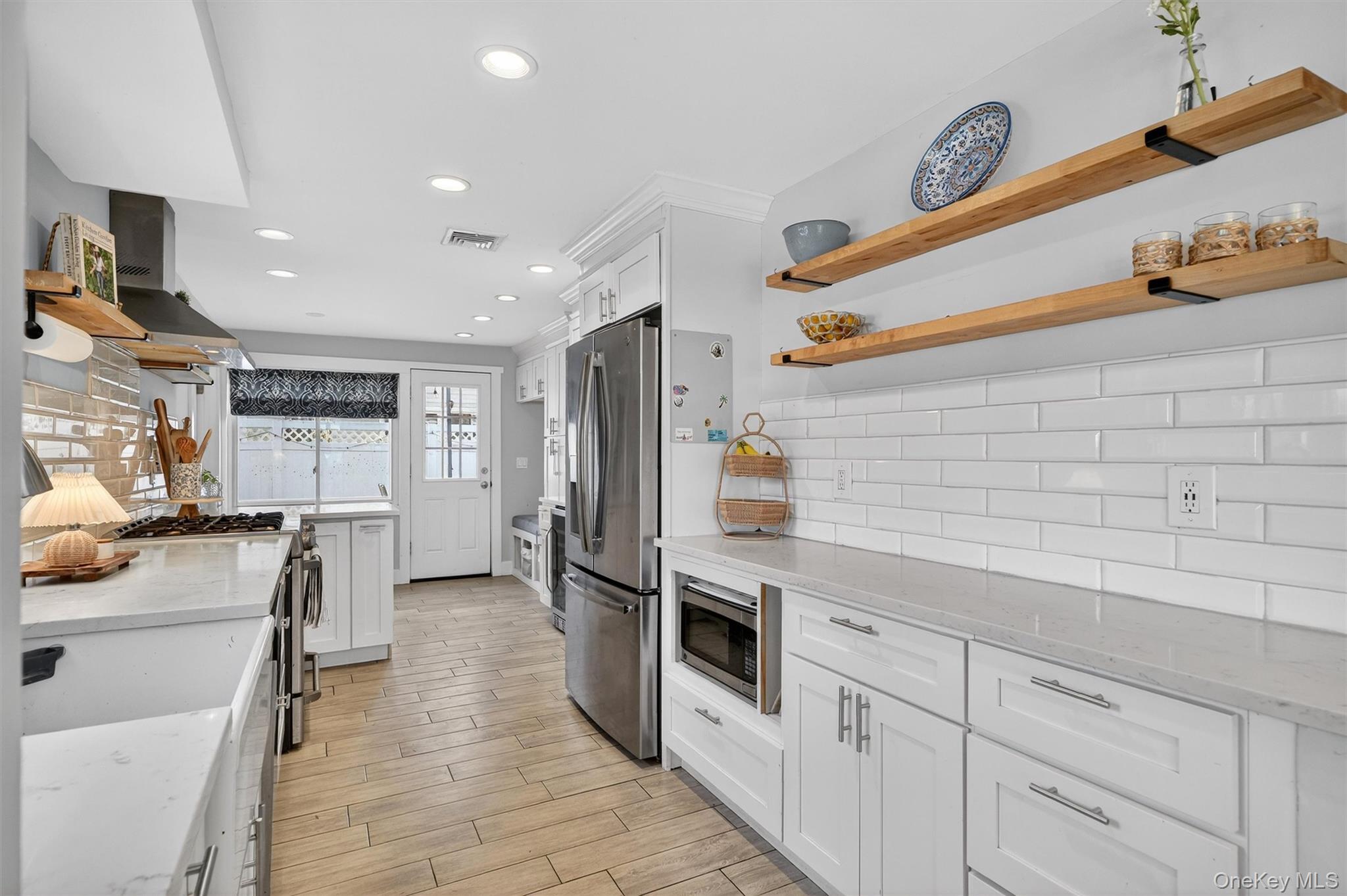 18 Lambert Lane New Rochelle, NY 10804 - Photo 12 of 47 Kitchen featuring open shelves, white cabinetry, light stone counters, tasteful backsplash, and recessed lighting