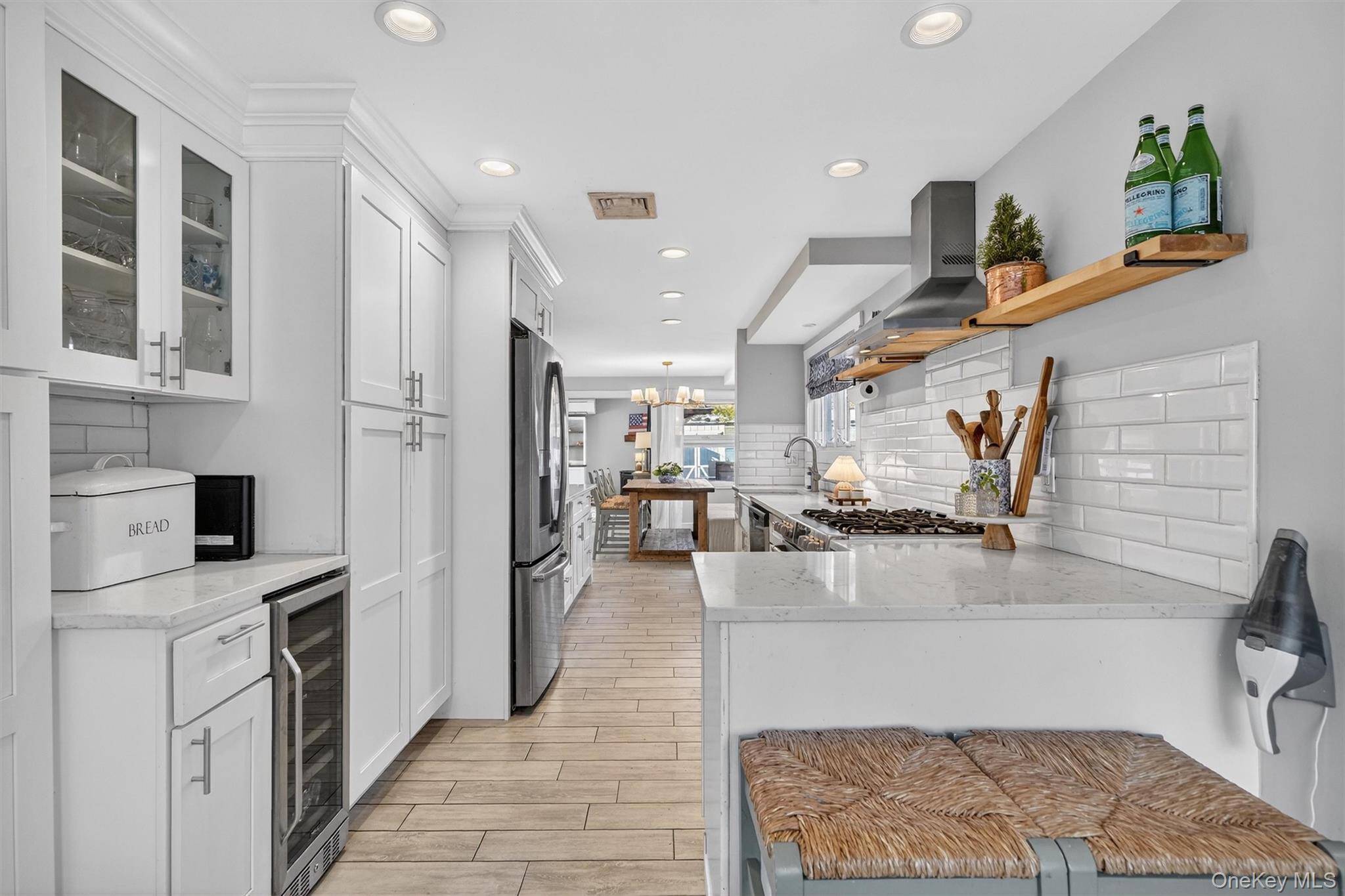 18 Lambert Lane New Rochelle, NY 10804 - Photo 15 of 47 Kitchen featuring light stone countertops, a peninsula, white cabinets, wood tiled floors, and recessed lighting