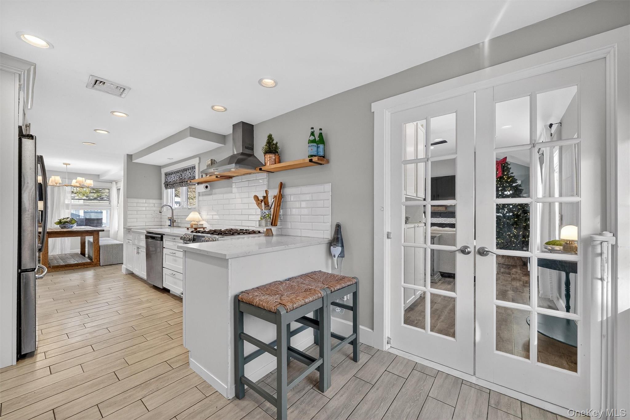 18 Lambert Lane New Rochelle, NY 10804 - Photo 17 of 47 Kitchen featuring a kitchen breakfast bar, open shelves, a peninsula, backsplash, and wood finish floors