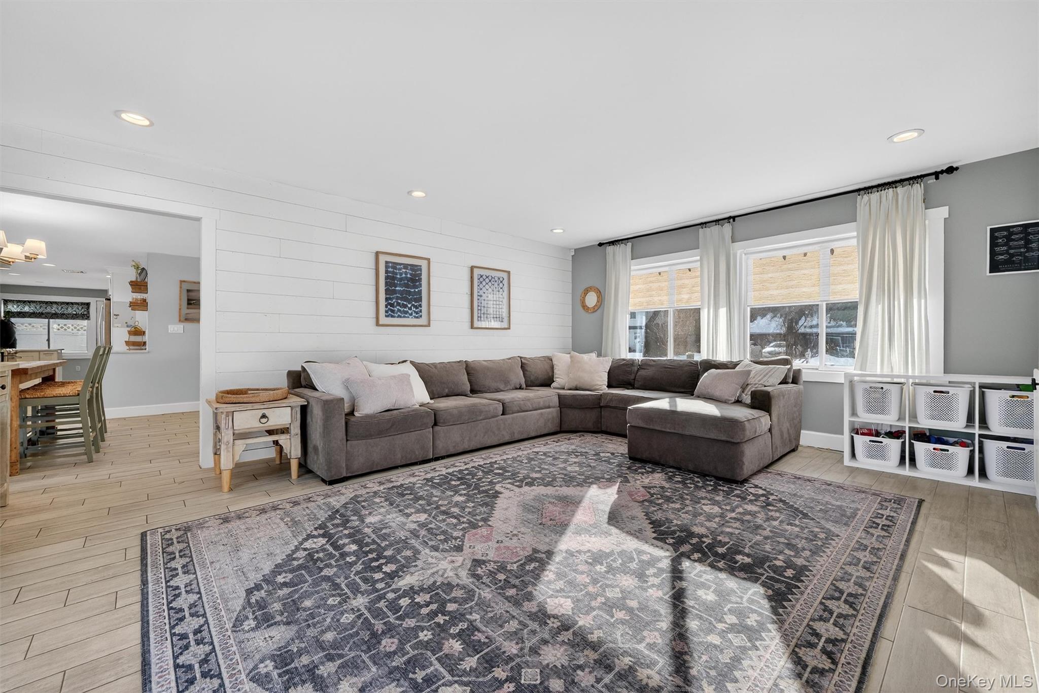 18 Lambert Lane New Rochelle, NY 10804 - Photo 26 of 47 Living room with light wood finished floors, wooden walls, recessed lighting, and a chandelier