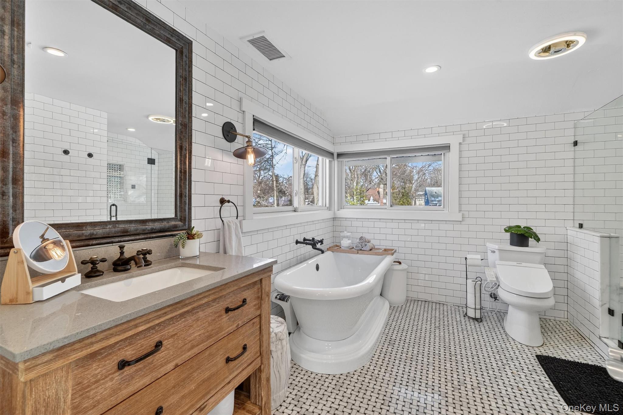 18 Lambert Lane New Rochelle, NY 10804 - Photo 31 of 47 Full bathroom with tile walls, a stall shower, a freestanding tub, vanity, and light tile patterned floors
