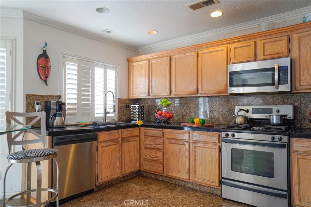 507 Lassa Way Perris, CA 92571 - Photo 18 of 36 a kitchen with stainless steel appliances a sink stove and microwave