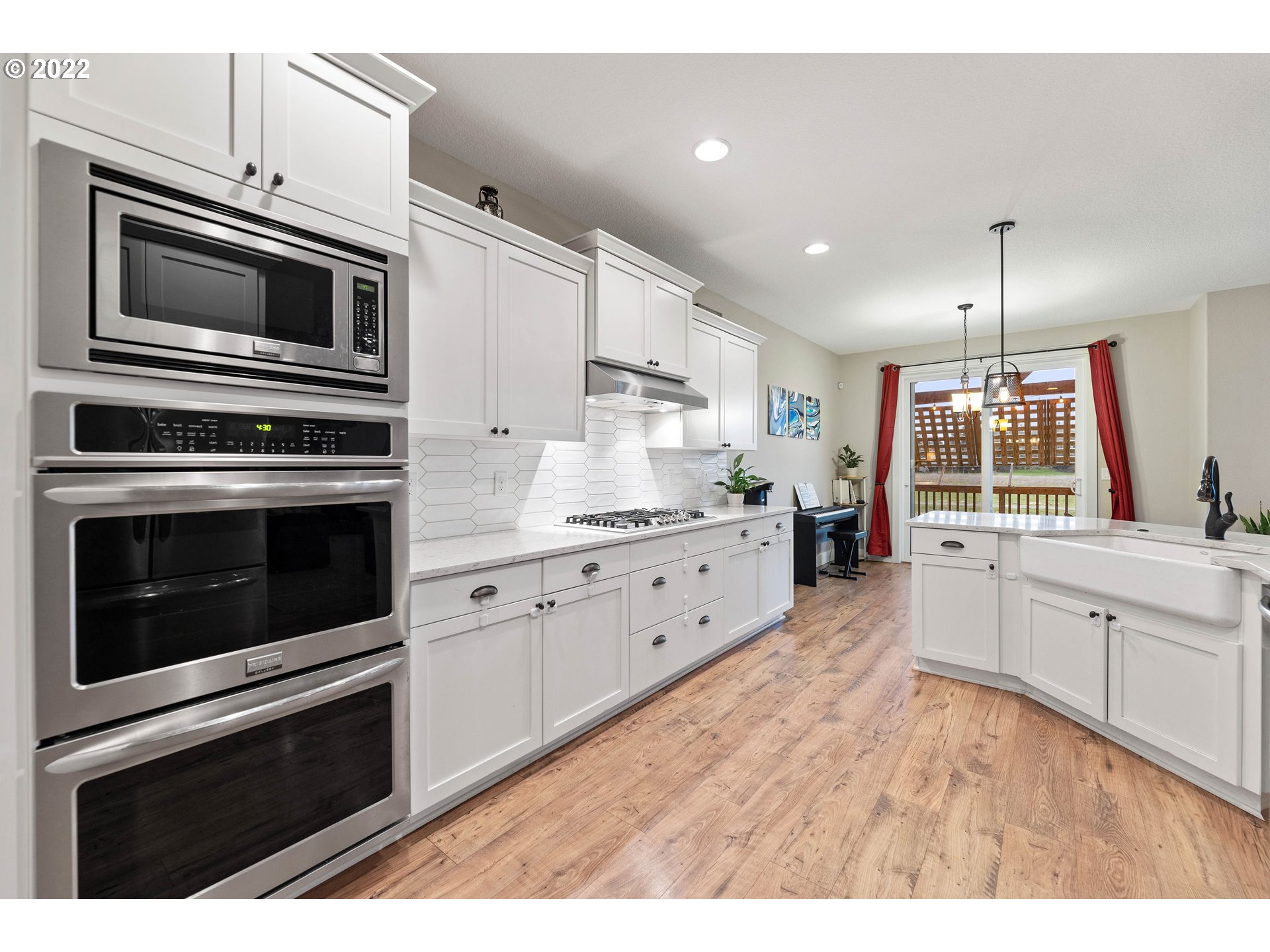 4616 South 16th Drive Ridgefield, WA 98642 - Photo 6 of 28 a kitchen with stainless steel appliances white cabinets a stove a sink and a microwave