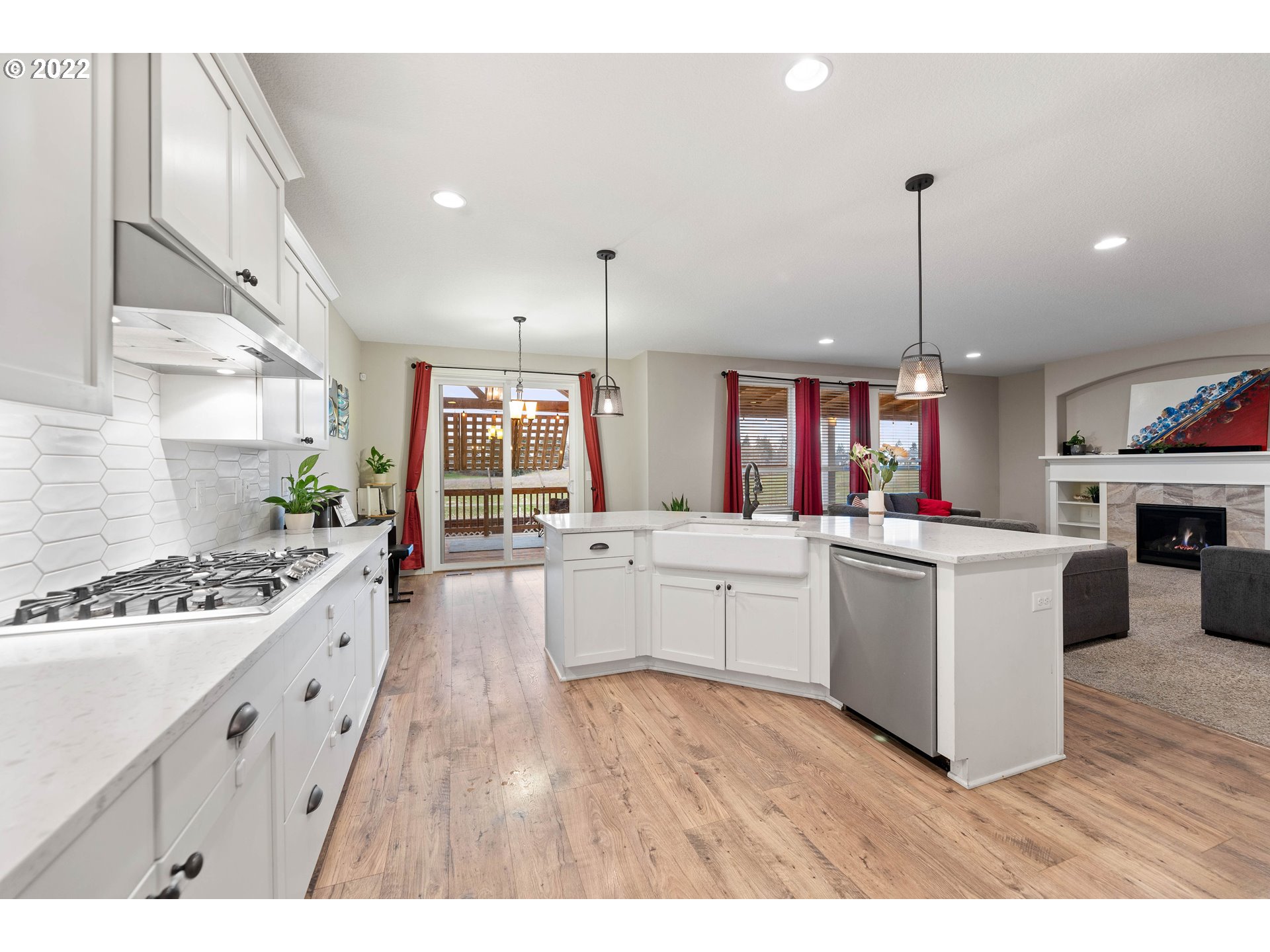 4616 South 16th Drive Ridgefield, WA 98642 - Photo 7 of 28 a large kitchen with kitchen island a stove a sink a refrigerator and a wooden floor