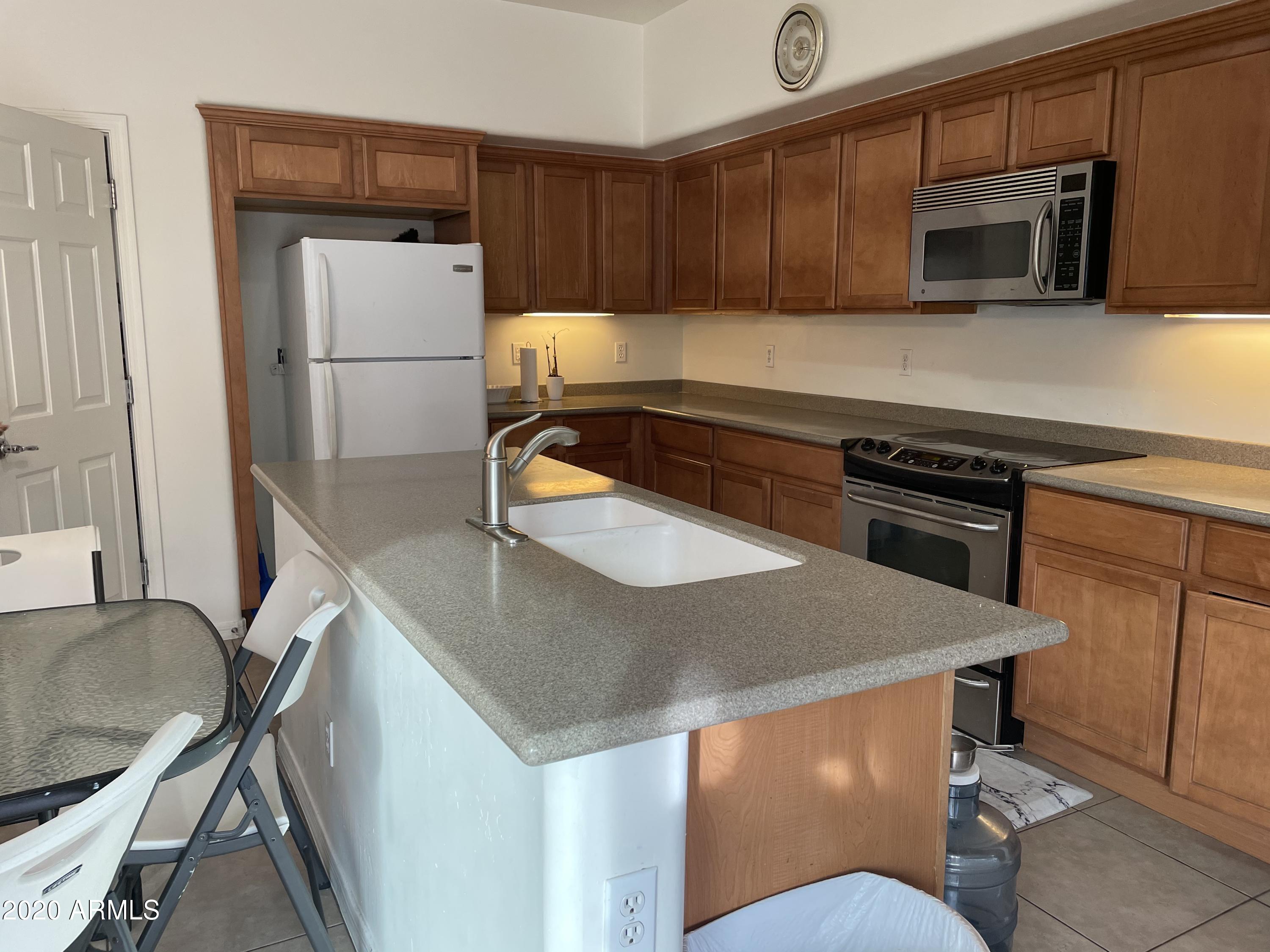 2023 West Davis Road Phoenix, AZ 85023 - Photo 5 of 16 a kitchen with stainless steel appliances a stove refrigerator sink and microwave
