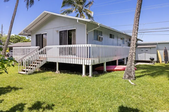 a view of a house with a yard and deck