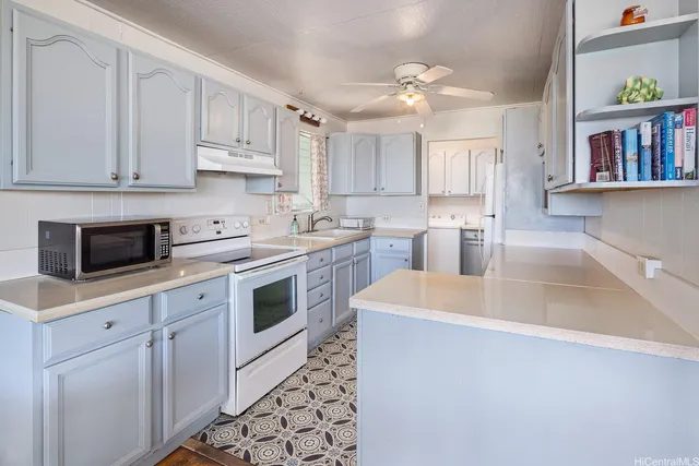 a kitchen with white cabinets a sink dishwasher and a stove with wooden floor