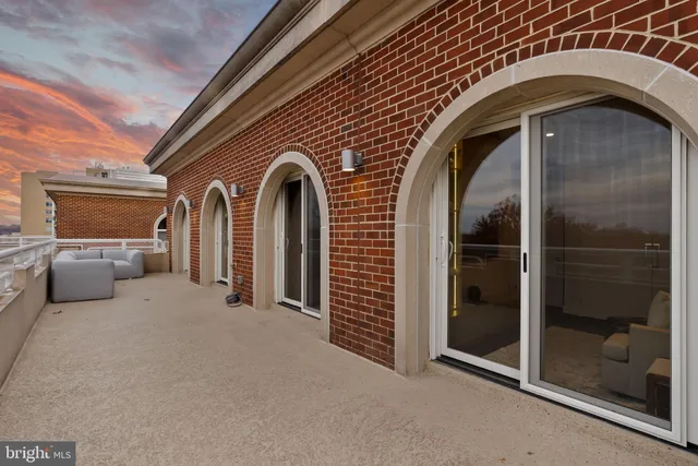 a view of hallway with stainless steel appliances wooden floor and entryway