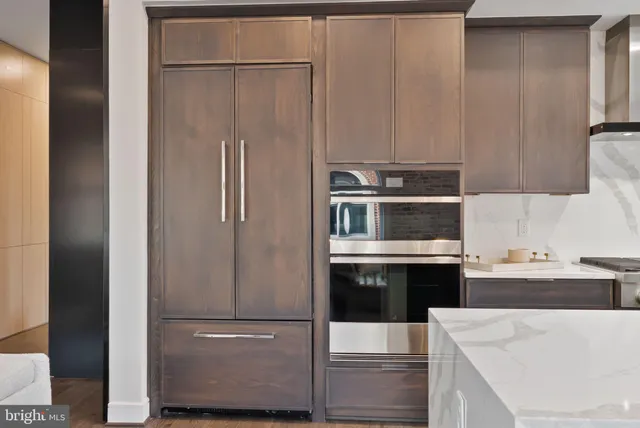 a kitchen with granite countertop a stove a sink and a refrigerator
